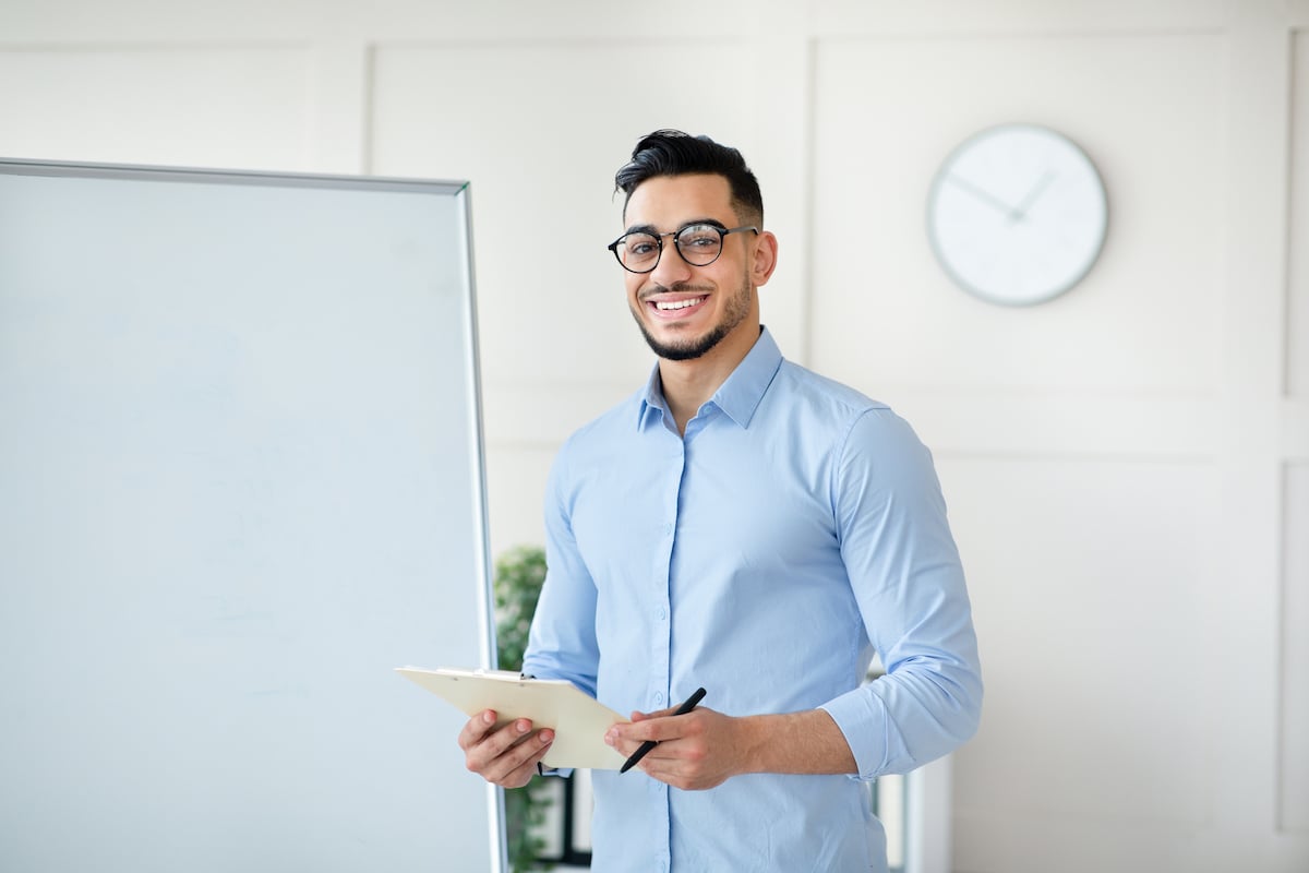 arab-male-teacher-standing-near-empty-blackboard-2021-12-09-08-17-52-utc